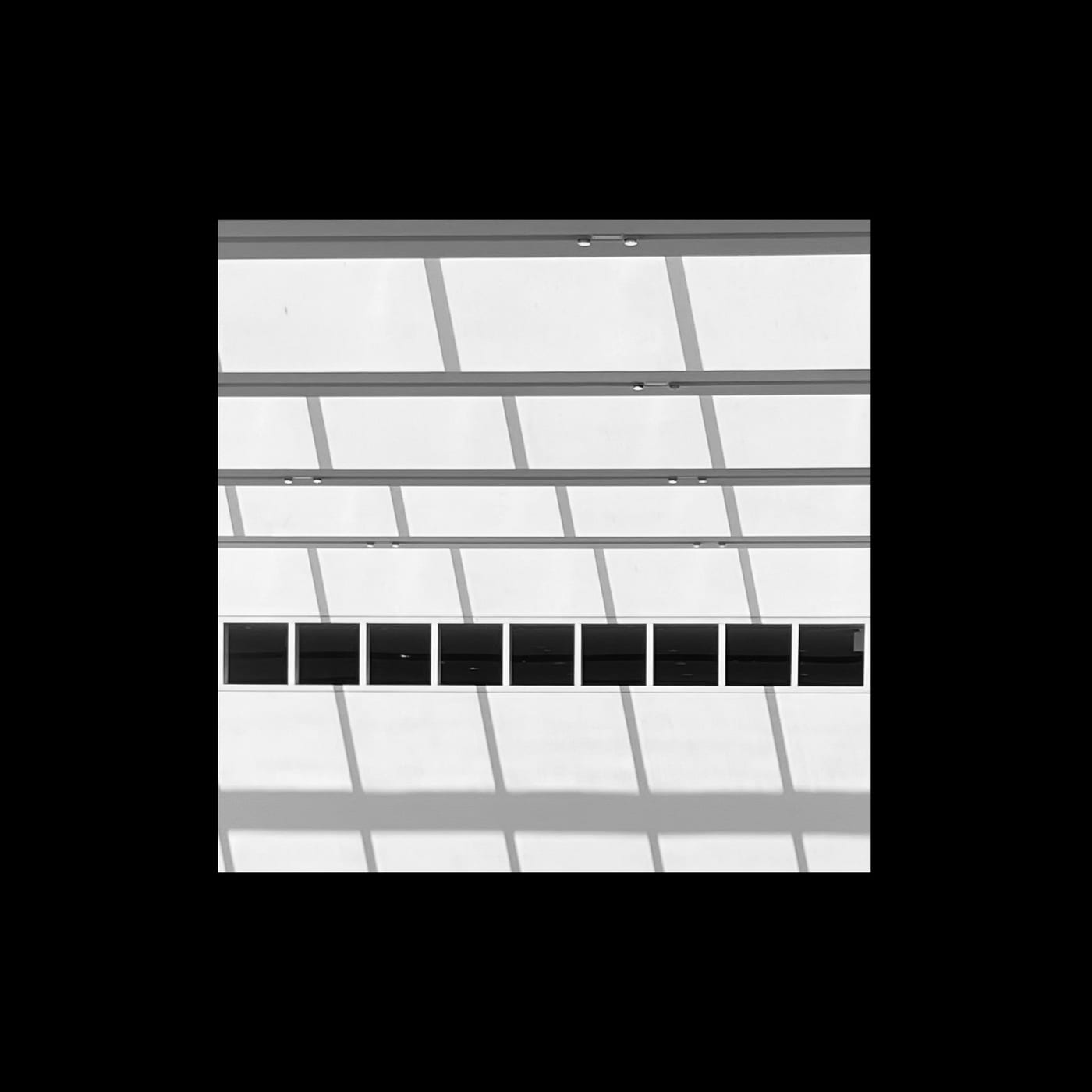 A white grid of window mullions broken by one dark row.