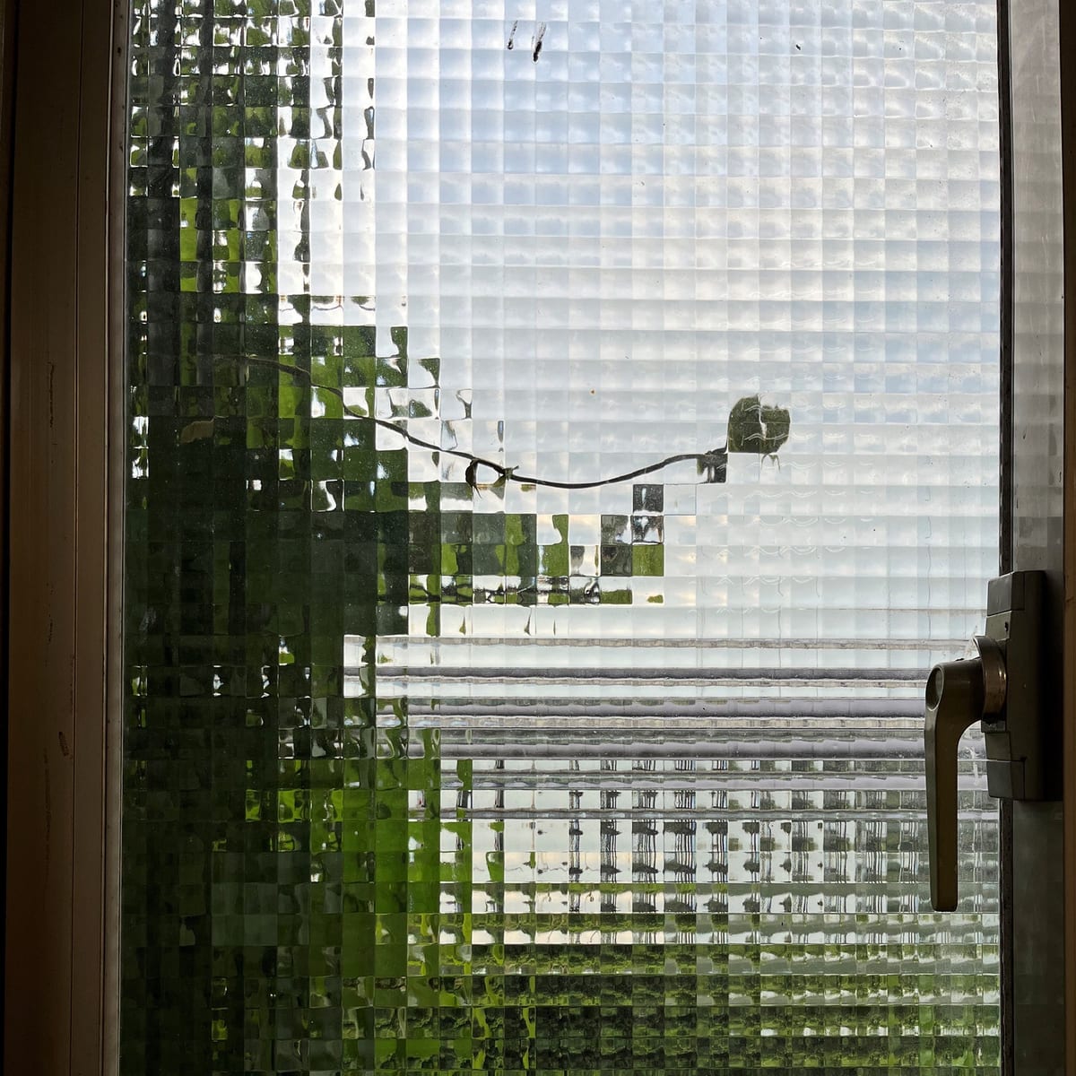 The original photograph: a glass-block window with a lamp behind it.