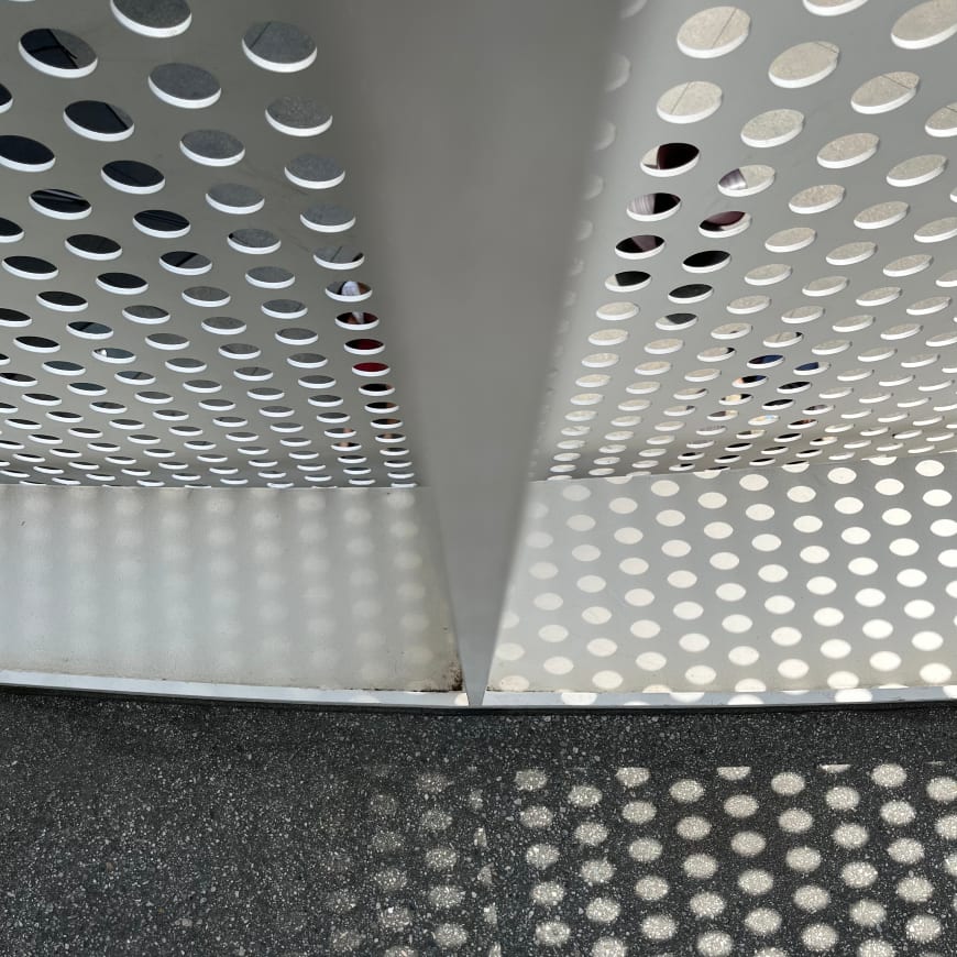 The original photograph: a perforated metal panel and ceiling.